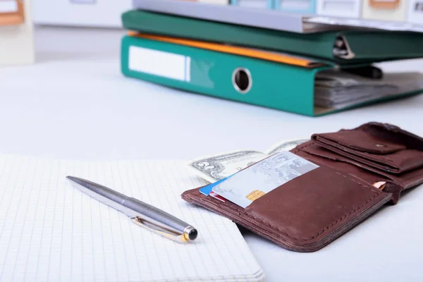 Folder file, note and wallet on the desk. blurred background.