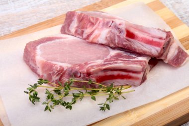 Çiğ domuz eti, baharat ve biberiye kesme tahtası üzerinde. Hazır yemek pişirmek için.