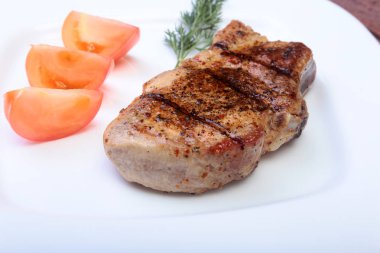 ahşap tahta üzerinde plaka üzerinde sebzeli ızgara domuz pirzolası