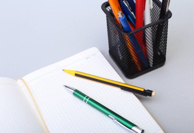 Açık boş sayfa defter ve kalem beyaz masada.