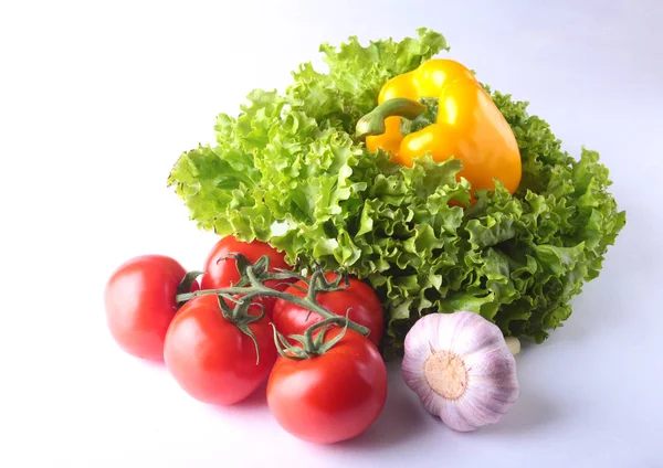 Свежие овощи перец колокольчик, помидор, чеснок с листьями салата. Изолированный на белом фоне. Селективный фокус . — стоковое фото