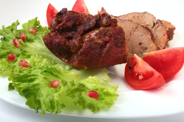 Стейк из мяса на гриле с помидорами, салатом и бобами граната на белой тарелке . — стоковое фото