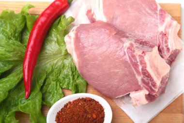 Çiğ Domuz pirzola otlar ile ve kesme tahtası üzerinde baharat. Hazır yemek pişirmek için.
