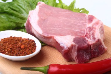 Çiğ Domuz pirzola otlar ile ve kesme tahtası üzerinde baharat. Hazır yemek pişirmek için.
