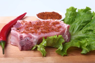 Çiğ Domuz pirzola otlar ile ve kesme tahtası üzerinde baharat. Hazır yemek pişirmek için.