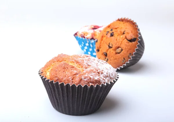 Muffins caseiros de mirtilo e chocolate com açúcar em pó e bagas frescas . — Fotografia de Stock