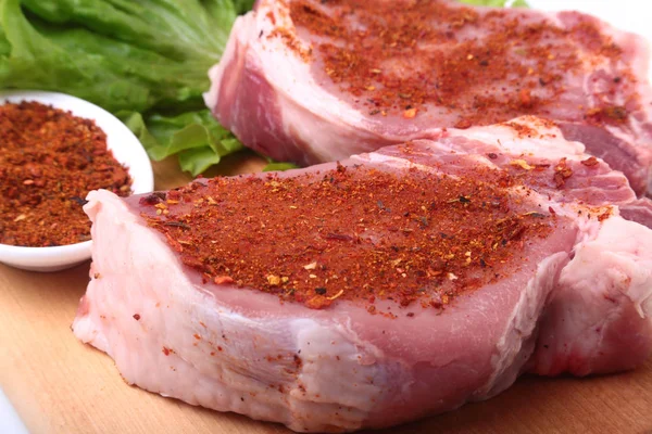 Raw pork chops with herbs and spices on cutting board. Ready for cooking. — Stock Photo, Image