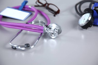 stetoskop, kırmızı kalp, gözlük ve beyaz arka plan üzerinde tansiyon ölçer. Seçici odak.