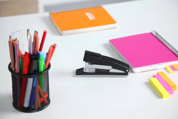 Primer plano de escritorio blanco con bloc de notas, bolígrafo, taza de café y otros artículos. Enfoque selectivo . —  Fotos de Stock