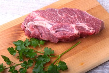 Ham sığır eti biftek baharatlar ile kişniş ahşap kesme tahtası üzerinde bırakır. Hazır yemek pişirmek için.