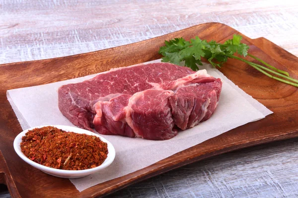 Steak de boeuf cru aux épices Feuilles de coriandre sur planche à découper en bois. Prêt pour la cuisson . — Photo