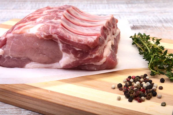 Côtelettes de porc crues, épices et romarin sur planche à découper. Prêt pour la cuisson . — Photo