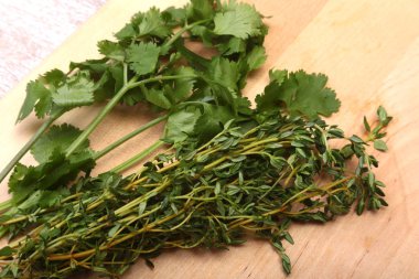 Taze yeşil kişniş, kişniş yaprakları ve biberiye ahşap tablo