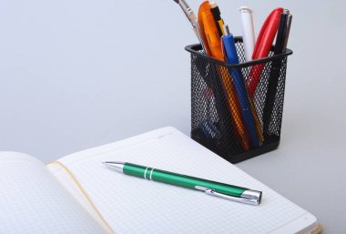 Açık boş sayfa defter ve kalem beyaz masada.