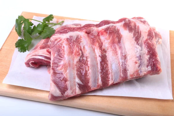 Raw pork ribs with herbs and spices on wooden board. Ready for cooking. — Stock Photo, Image