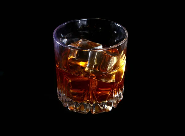 Verre de whisky ou de bourbon avec glace sur table en pierre noire . — Photo