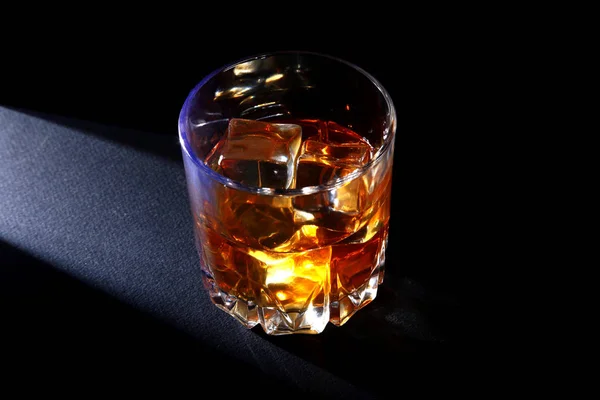 Glass of whiskey or bourbon with ice on black stone table. — Stock Photo, Image