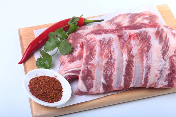 Raw pork ribs with herbs and spices on wooden board. Ready for cooking. — Stock Photo, Image