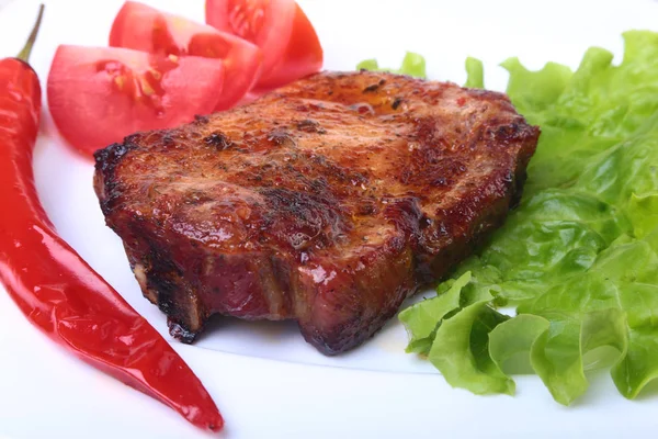 Steak z grilovaného masa a chilli s rajčaty, salátových listů na bílé plotně. — Stock fotografie