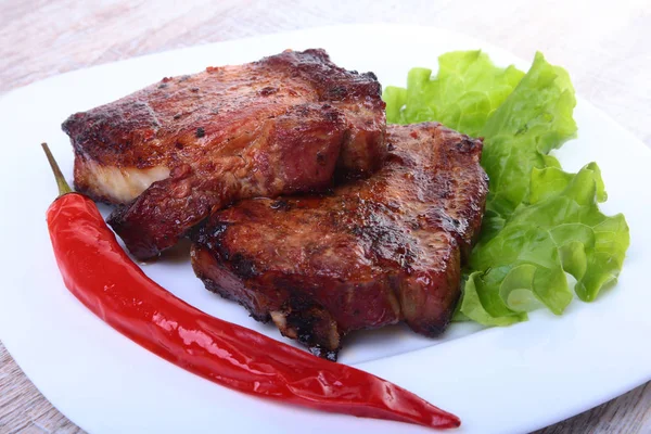 Steak daging panggang dan cabai dengan tomat, daun selada di piring putih . — Stok Foto