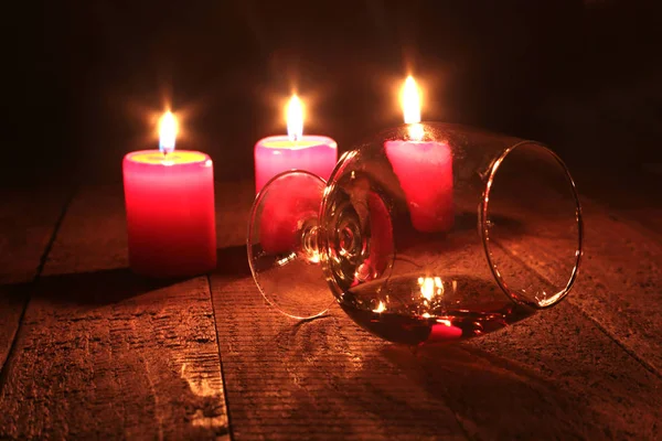 Composición navideña con coñac de vidrio, caja de regalo y vela sobre mesa de madera — Foto de Stock