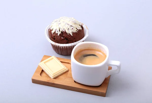 Café expresso clássico em xícara branca com bolo caseiro e chocolate em fundo branco . — Fotografia de Stock
