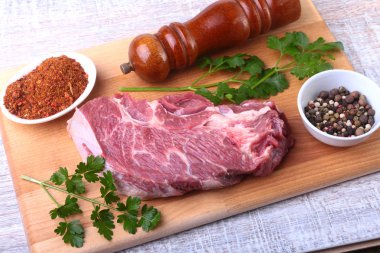 Ham sığır eti biftek baharatlar ile kişniş ahşap kesme tahtası üzerinde bırakır. Hazır yemek pişirmek için.