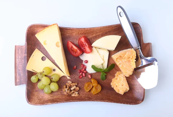 Meyve, üzüm, fındık ve peynir bıçağı bir ahşap servis tepsi ile peynir çeşitleri.