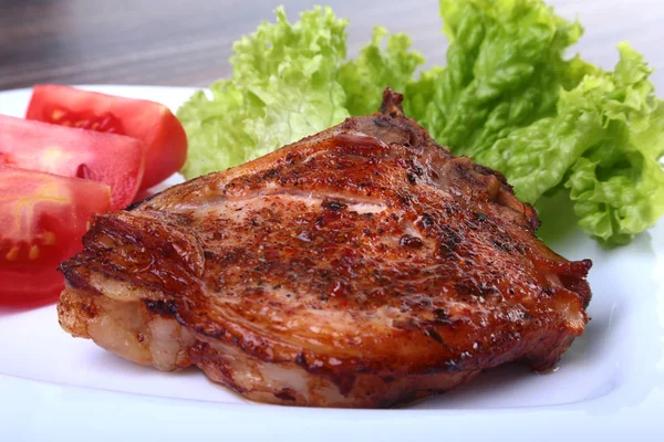 Chuletas de cerdo a la parrilla con tomate, lechuga de hojas y ketchup en el plato . — Foto de Stock