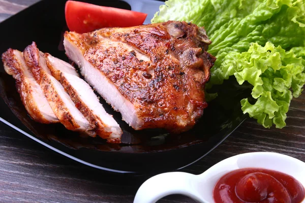 Gegrillte Schweinekoteletts mit Tomaten, Salat und Ketchup auf Teller. — Stockfoto