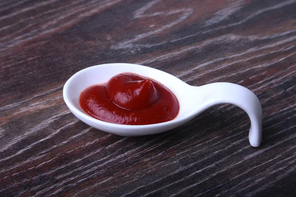 Bol en porcelaine blanche de ketchup ou sauce tomate isolé sur fond en bois . — Photo