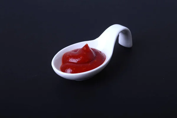 Białe porcelanowe miski sos pomidorowy lub ketchup na białym na czarnym tle. — Zdjęcie stockowe