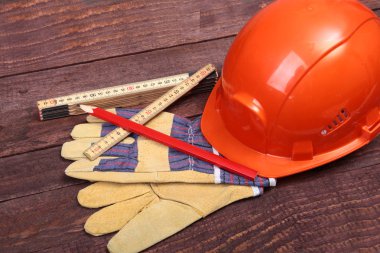 Turuncu zor şapka ve eldiven ahşap arka plan üzerinde çalışmak için.