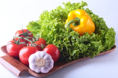 Taze çeşitli sebze çan biber, domates, sarımsak yaprak marul ile. Beyaz arka plan üzerinde izole. Seçici odak.