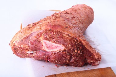 Çiğ domuz knuckle ve baharat bir kesme tahtası üzerinde. Seçici odak. Hazır yemek pişirmek için.