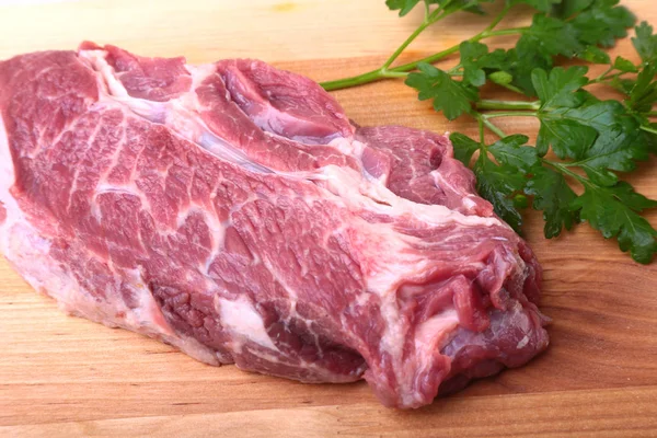 Raw beef steak with spices Leaves of coriander on wooden cutting board. Ready for cooking. — Stock Photo, Image