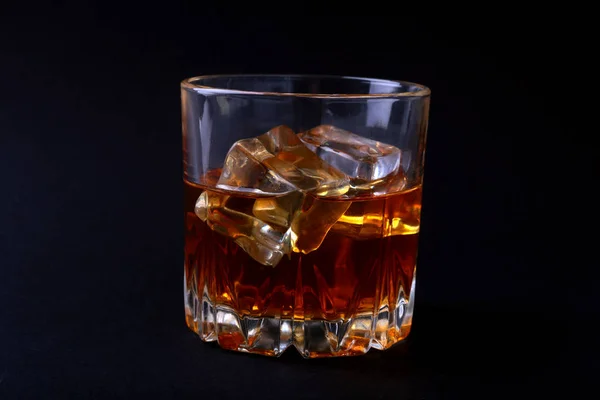 Glass of whiskey or bourbon with ice on black stone table. — Stock Photo, Image