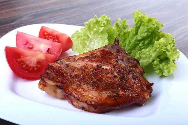 Grilled pork chops with tomato, leaves lettuce and ketchup on plate. — Stock Photo, Image