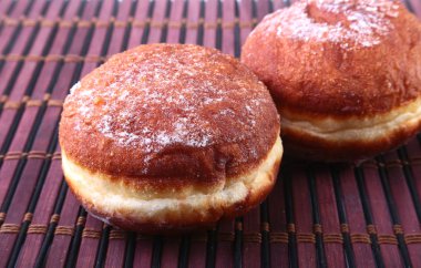Jöle ile ev yapımı çörek dolu ve pudra şekeri bambu masa örtüsü üzerinde. Seçici odak.
