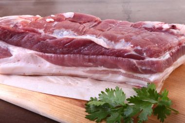 Çiğ domuz eti baharat ile kişniş ahşap kesme tahtası üzerinde bırakır. Hazır yemek pişirmek için.