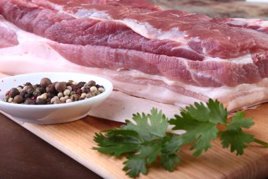 Çiğ domuz eti baharat ile kişniş ahşap kesme tahtası üzerinde bırakır. Hazır yemek pişirmek için.