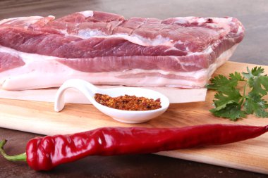 Çiğ domuz eti baharat ile kişniş ahşap kesme tahtası üzerinde bırakır. Hazır yemek pişirmek için.