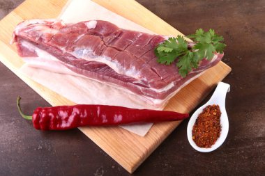 Çiğ domuz eti baharat ile kişniş ahşap kesme tahtası üzerinde bırakır. Hazır yemek pişirmek için.
