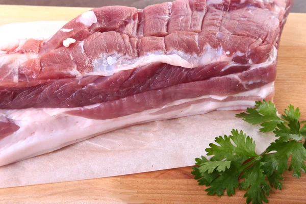 Raw pork meat with spices Leaves of coriander on wooden cutting board. Ready for cooking. — Stock Photo, Image