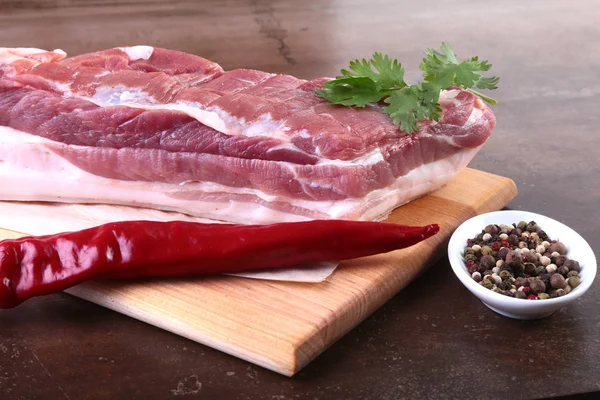 Çiğ domuz eti baharat ile kişniş ahşap kesme tahtası üzerinde bırakır. Hazır yemek pişirmek için.