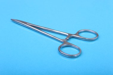 Yakın kadar cerrahi aletler ve araçlar mavi ayna arka plan üzerinde. Seçici odak.