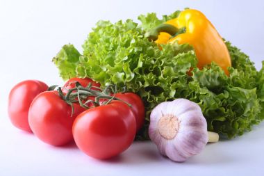 Taze çeşitli sebze çan biber, domates, sarımsak yaprak marul ile. Beyaz arka plan üzerinde izole. Seçici odak.