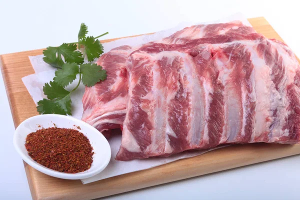 Otlar ve baharatlar ahşap tahta üzerinde çiğ Domuz kaburga. Hazır yemek pişirmek için.