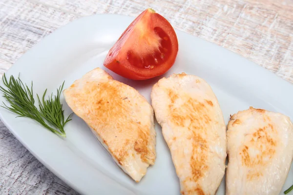 Fatias de peito de frango assado e tomate na placa branca — Fotografia de Stock