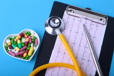 Stetoskop, Rx reçeteli ve renkli ürün yelpazesine hap ve kapsül plaka üzerinde.